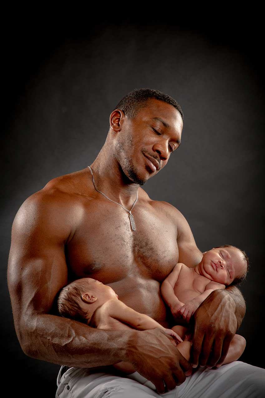 Father holding two newborn babies